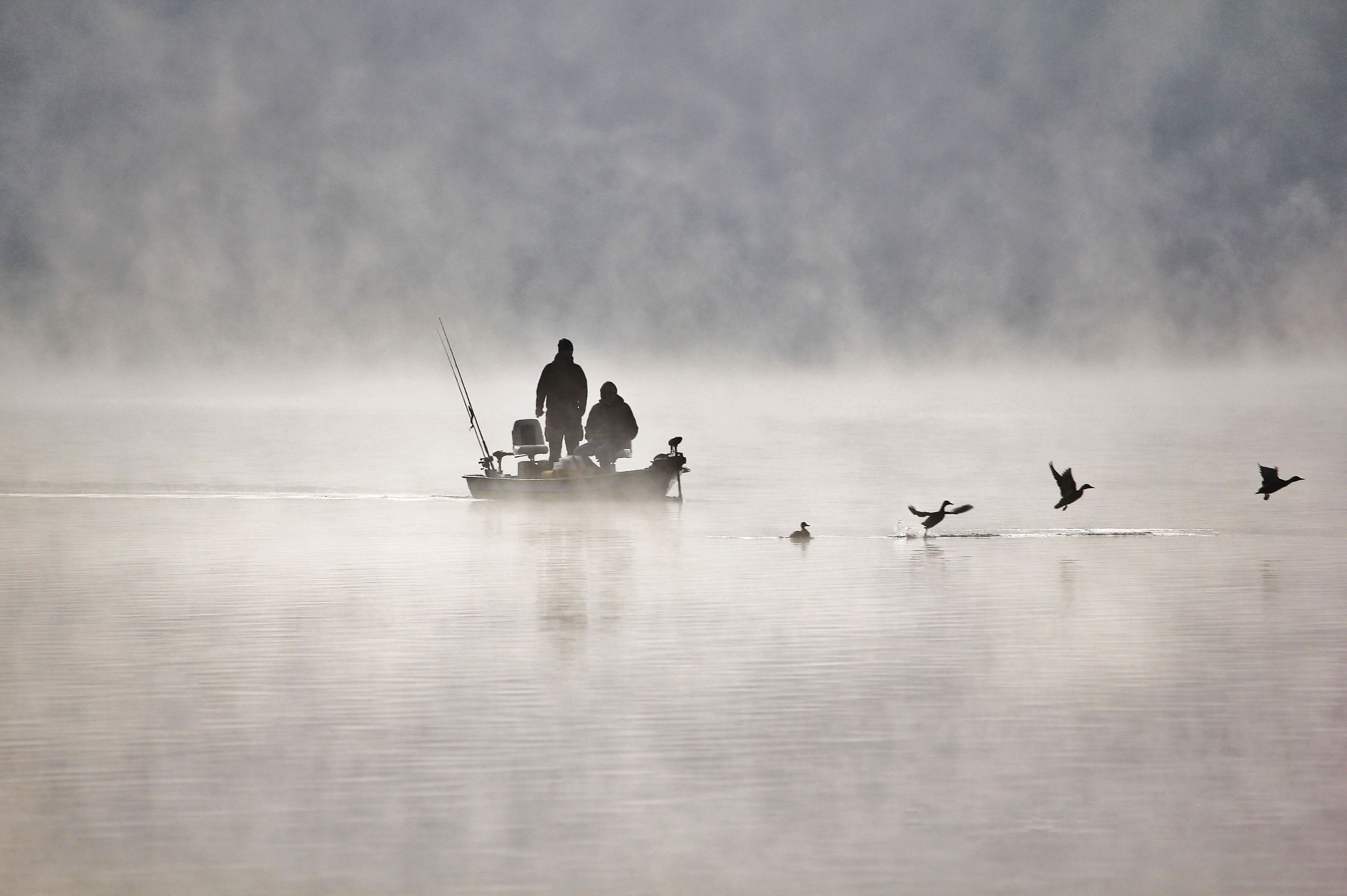 Ein kleines Boot mit Anglern auf dem Edersee im Nebel