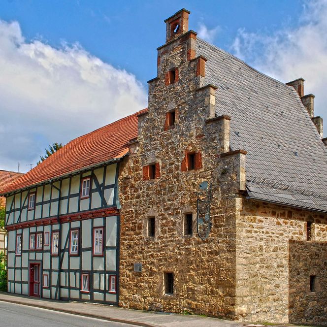 Ein gotisches Lagerhaus aus Stein mit einem angrenzenden Fachwerkhaus.