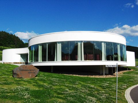 Das NationalparkZentrum Kellerwald von aussen - ein rundes Gebäude mit einer großen Fensterfront.