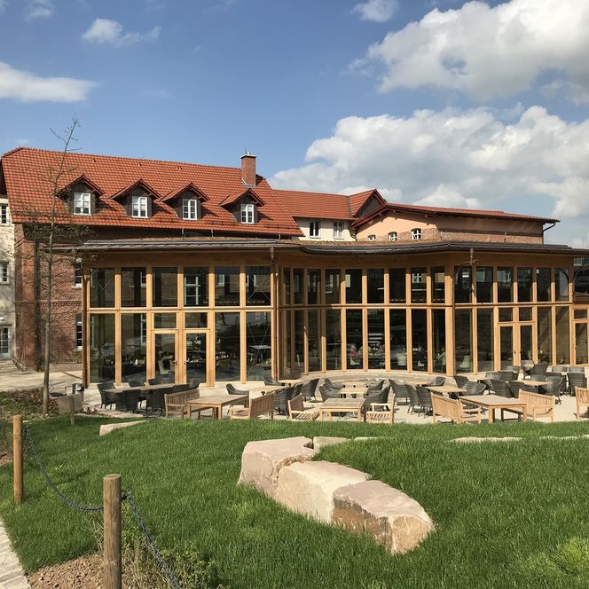 Aussenansicht des Restaurants Brunnenhaus Schloss Landau mit einigen Aussensitzplätzen.