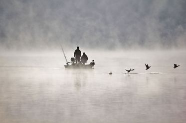 Ein kleines Boot mit Anglern auf dem Edersee im Nebel
