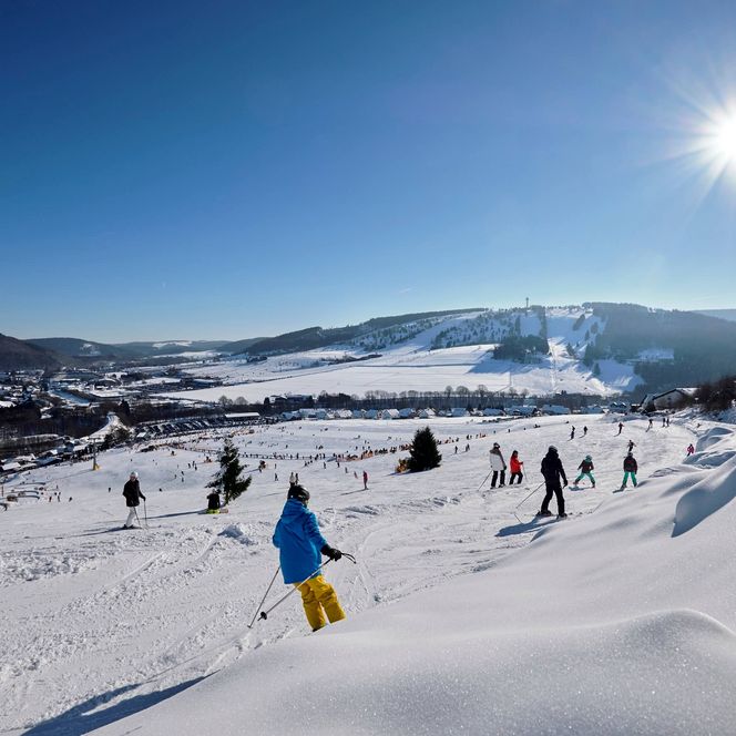 Skihang in Willingen mit Skifahrern im Schnee, Wintersportler in bunter Ausrüstungstimmung