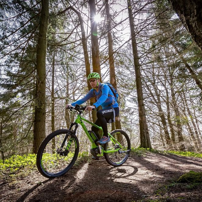 Ein E-Bike Fahrer fährt einen Green Trail im Wald.