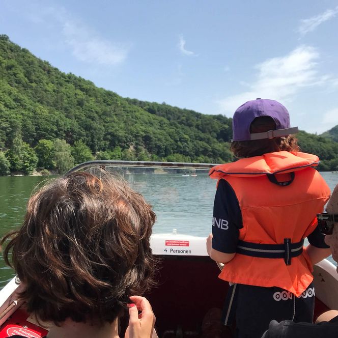 Eine Familie macht eine Bootsfahrt auf dem Diemelsee im Sommer.