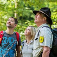 Ein Ranger zeigt zwei Wanderern den Nationalpark