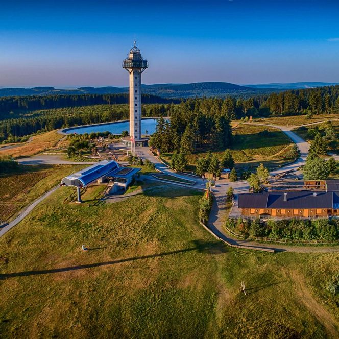 Auf dem Drohnenfoto sieht man das Hochplateau des Willinger Ettelsbergs mit dem Hochheideturm, der Ettelsberg-Bahn, Siggis Hütte, dem Spielplatz, dem Pumpspeicherbecken und dem überdimensionalem Holzstuhl im Hintergrund. Auch Wanderwege und Mountainbike-Strecken sind zu erkennen.