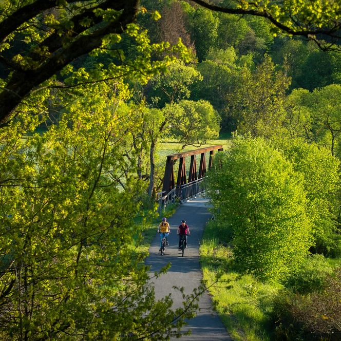 Zwei Radlerinnen vor der Ederbrücke bei Hatzfeld-Holzhausen inmitten von Wald