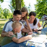 Pause vom Radfahren am Ederseebahn-Radweg Eine Familie sitzt an einem Rastplatz am Ederseebahn-Radweg und studiert Karten
