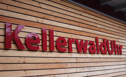 Der Schriftzug Kellerwalduhr in roten Buchstaben auf einer Holzwand