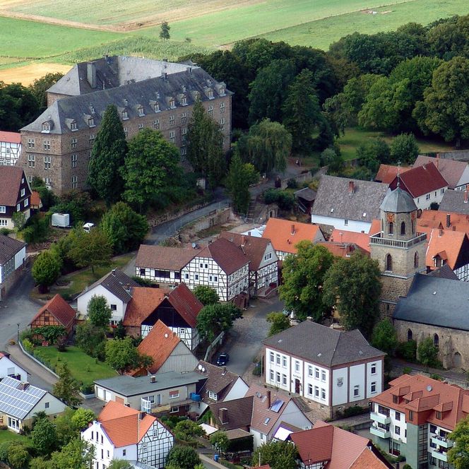 Eine Luftaufnahme auf der das Schloss Diemelstadt, das Rathaus und die Fachwerkhäuser der Stadt zu sehen sind. 