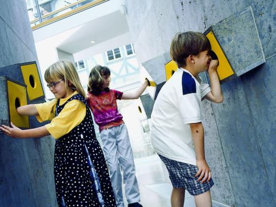 Kinder an den Fühlkästen zum Thema Handwerk